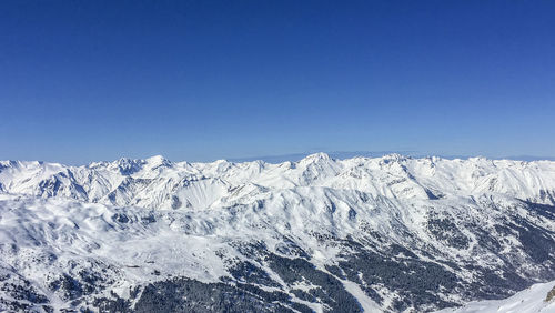 Scenic view of snowcapped mountains against clear blue sky