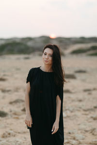 Beautiful young woman standing on beach