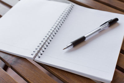 Close-up of pen on open book over table