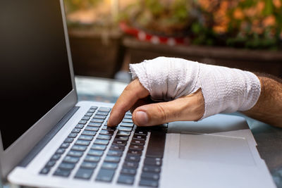 Person with injured wrist typing on laptop person