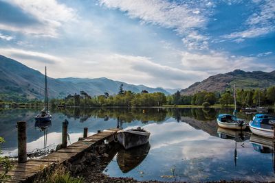 Boats moored in lake against sky