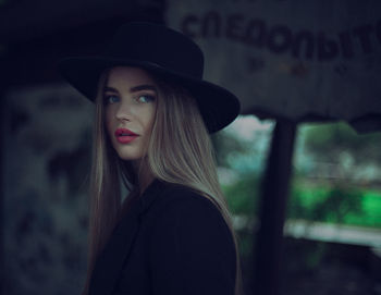 Portrait of woman with long hair wearing hat looking away