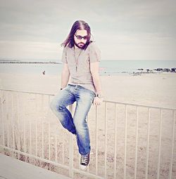 Portrait of young woman against sea against sky