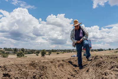 Side view of woman standing on field against sky