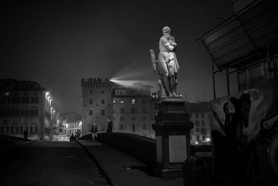 Statue of illuminated city at night