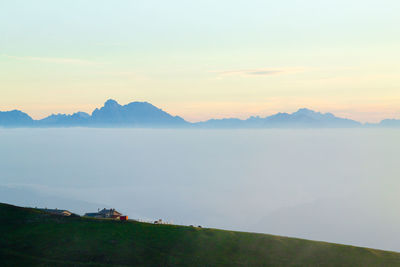 Scenic view of lake and mountains against sky during sunset