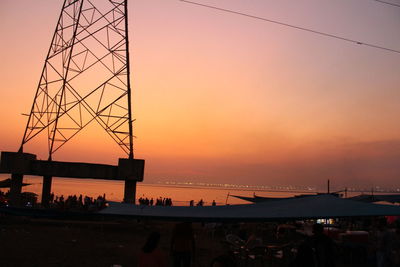 Silhouette people at commercial dock against sky during sunset