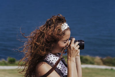 Woman photographing by sea