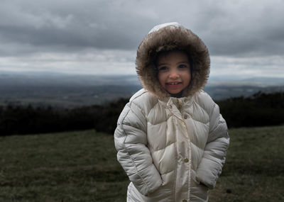 Portrait of smiling girl standing on field