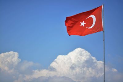 Low angle view of turkish flag fluttering against the sky