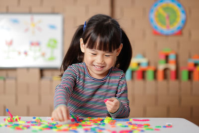 Cute boy playing with ball on table