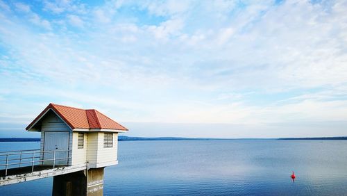 Lifeguard hut by sea against sky