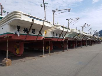 Boats moored at harbor against sky