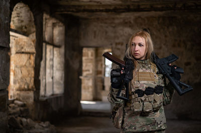 Portrait of young woman standing against wall