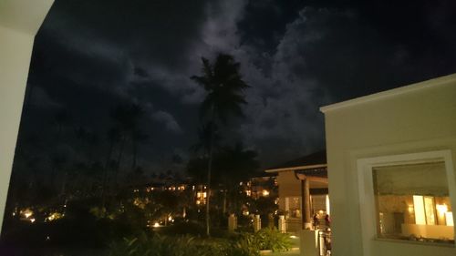 Illuminated city against cloudy sky