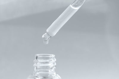 Pipette with transparent fluid hyaluronic acid or serum. cosmetics, science and healthcare concept 