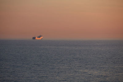 Commercial ship crossing the sea at sunset.
