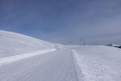 Snow covered land against sky