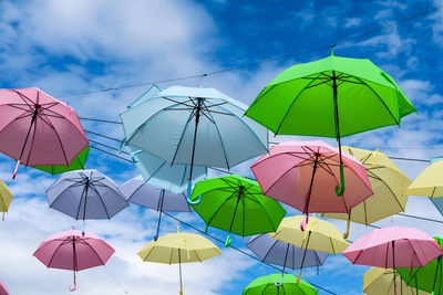 Low angle view of umbrellas hanging against sky