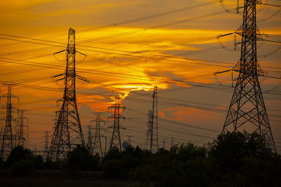 Low angle view of electricity pylon against romantic sky