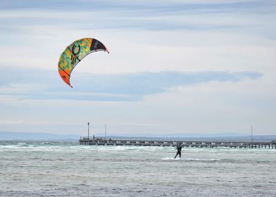 People paragliding over sea against sky