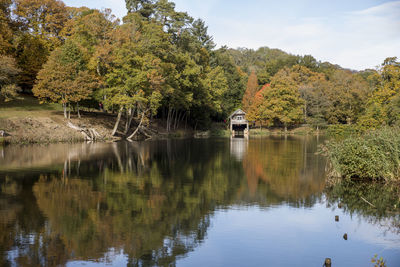 Scenic view of lake by trees against sky