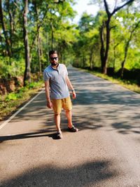 Full length portrait of man wearing sunglasses on road