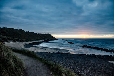 Scenic view of beach against sky during sunset