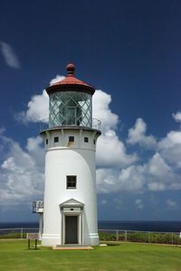 Lighthouse by sea against sky