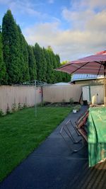 Tent on field by house against sky