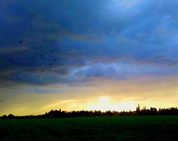 Scenic view of agricultural field against dramatic sky