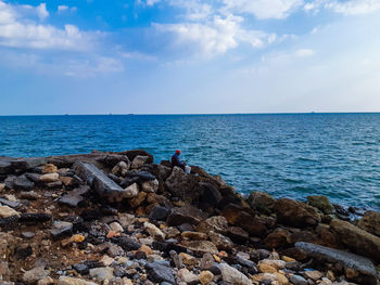 Scenic view of rocks in sea against sky