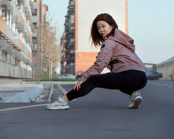 Portrait of young woman exercising on road