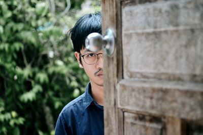 Portrait of man peeking through window