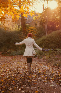Rear view of woman standing in park during autumn