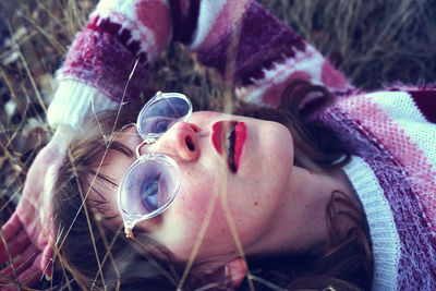 Close-up of young woman lying on field