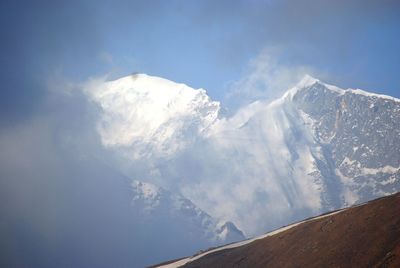 Low angle view of snowcapped mountains against sky