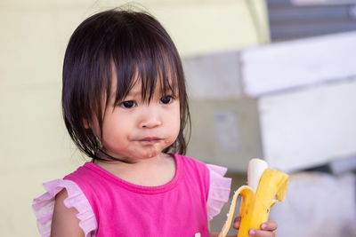 Cute baby girl eating banana