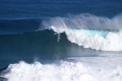 Scenic view of waves in sea against sky