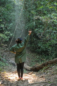 Full length rear view of woman standing in forest