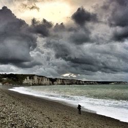 Scenic view of beach against cloudy sky