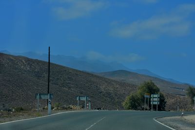 Empty road by mountain against sky