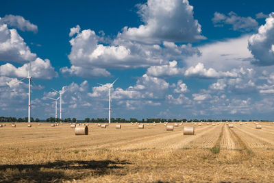 Hay bales on field against sky