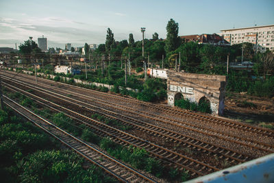 High angle view of railroad tracks by buildings against sky