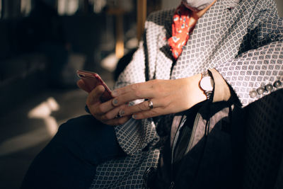 Midsection of man using mobile phone