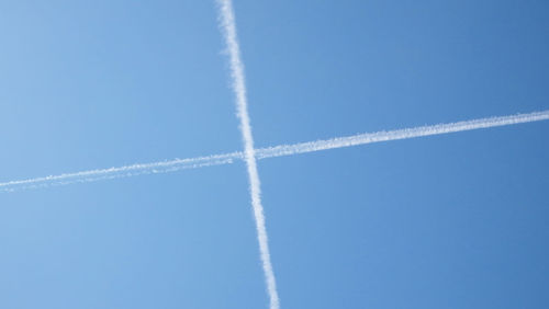 Low angle view of vapor trail against blue sky