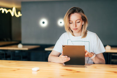 Portrait of woman holding smart phone on table