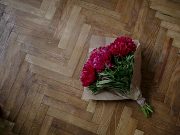 High angle view of peonies bouquet on hardwood floor