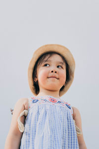 Portrait of cute girl wearing hat against white background