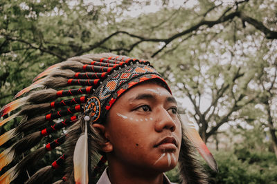Close-up of young man wearing headdress looking away